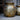 Decorative metal vase with textured surface on a neutral background