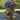 Large antique-style lion head planter with a rustic gold finish, designed with a detailed mane, displayed on a wicker table and filled with vibrant blue, pink, and purple hydrangeas.