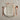 Table setting with copper cutlery on a beige plate with a napkin on a textured surface.