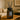 Dark glass amberwood and musk reed diffuser with black sticks on a wooden table in a living room setting