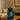 Blue diffuser bottle labeled 'Bergamot & Vanilla' on a wooden table with a blurred living room background.