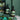 Two black bottles with decorative labels on a green background