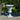 Large rustic planter in an urn shape on a stone patio with greenery in the background