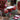 Set of red candles in a decorative box on a wooden surface with other candle products.