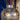 Decorative vase with floral arrangement against a blue and gold background
