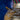 Close-up of a textured gold vase with a blurred blue background