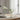 Dining table setting with a green champagne glass, plates, and cutlery on a wooden table.