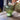 Green ribbed glass lamp on a wooden surface with blurred background