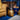 Gold armchair and side table with decorative items in a room with blue walls.