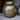 Decorative gold metal vase with intricate patterns on a textured surface