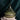 Green glass candle with a textured lid on a dark background