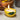 A ceramic candle designed to look like a yellow lemon with a green leaf, being lit with a match.