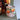 Decorative candle with pumpkin design on a shelf with other items.