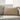 Cream pillow with tassels on a light gray sofa