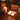 Candlelit scene with decorative items on a table, including a globe and small boxes.