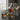 Set of tumbler glasses with whiskey and a decanter on a dark surface with candles in the background