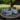 Three rustic metal buckets on a wicker table outdoors with a tree and grass in the background.