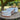 Three rustic metal buckets on a table outdoors with trees and logs in the background