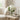 White hydrangeas in a glass vase on a side table in a neutral living room