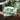 Set of green candles with decorative packaging on a wooden surface