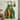 Green kitchen apron with yellow and red tomatoes design hanging up in kitchen.