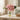 Pink flowers in a clear vase on a table with a neutral background