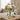 Clear vase with pink and white flowers on a wooden coffee table in a living room.