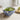 Bowl of guacamole with tortilla chips and a lime on a light surface.