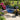 Blue egg chair outdoor in a garden setting with flowers and statues