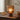 Ridged glass lamp on wooden table with books and a bowl