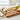 Cheese knives set styled on wooden board with cheese, crackers and grapes