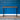 Minimalist console table with wood top and black metal frame positioned against a blue panelled wall.