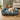Cockapoo dog lying on a floral-patterned dog bed with sides in a cozy living room.