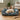 Fluffy cockapoo dog lying on a floral-patterned dog bed with sides in a cozy living room.
