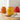 Yellow glass jar on wooden board on top of kitchen countertop, with red and orange jars in background.