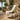 Green egg chair outdoor with a white blanket on a patio with potted plants and a drink.