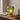 Green glass table lamp on a wooden surface with a notebook and pen.