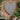 Grey wicker heart wall decor on brick wall in garden setting