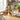 White pitcher with painted tomatoes and green handle on kitchen countertop.