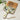 Wooden cutting board with a decorative handle featuring olive design on a marble surface.