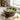 Wooden salad bowl with a leaf pattern containing a salad on a kitchen counter.