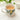 Ceramic mug with lemon and leaf design filled with a warm beverage on a white surface.