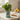 A potted mint small artificial plant in a vintage-style metal tin planter sits on a kitchen countertop