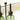 Green glass bottles with black metal lids on a light background