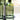 Green glass bottle labeled 'Vinegar' on a black stand with a blurred outdoor background.