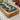 Wooden tray with a ceramic inset featuring floral patterns on a light surface.