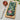 Rectangular wooden board with pomegranate design, knife, and pomegranate on a light surface