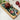 Pomegranate on a decorative cutting board with a knife, set against a marble background.