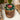 Wooden container with a decorative lid featuring pomegranates and leaves on a marble surface.
