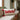 rectangle cushion: lifestyle view 1 of the rectangular bouclé cushion with ho ho ho embroidery and tassels styled in a festive home setting